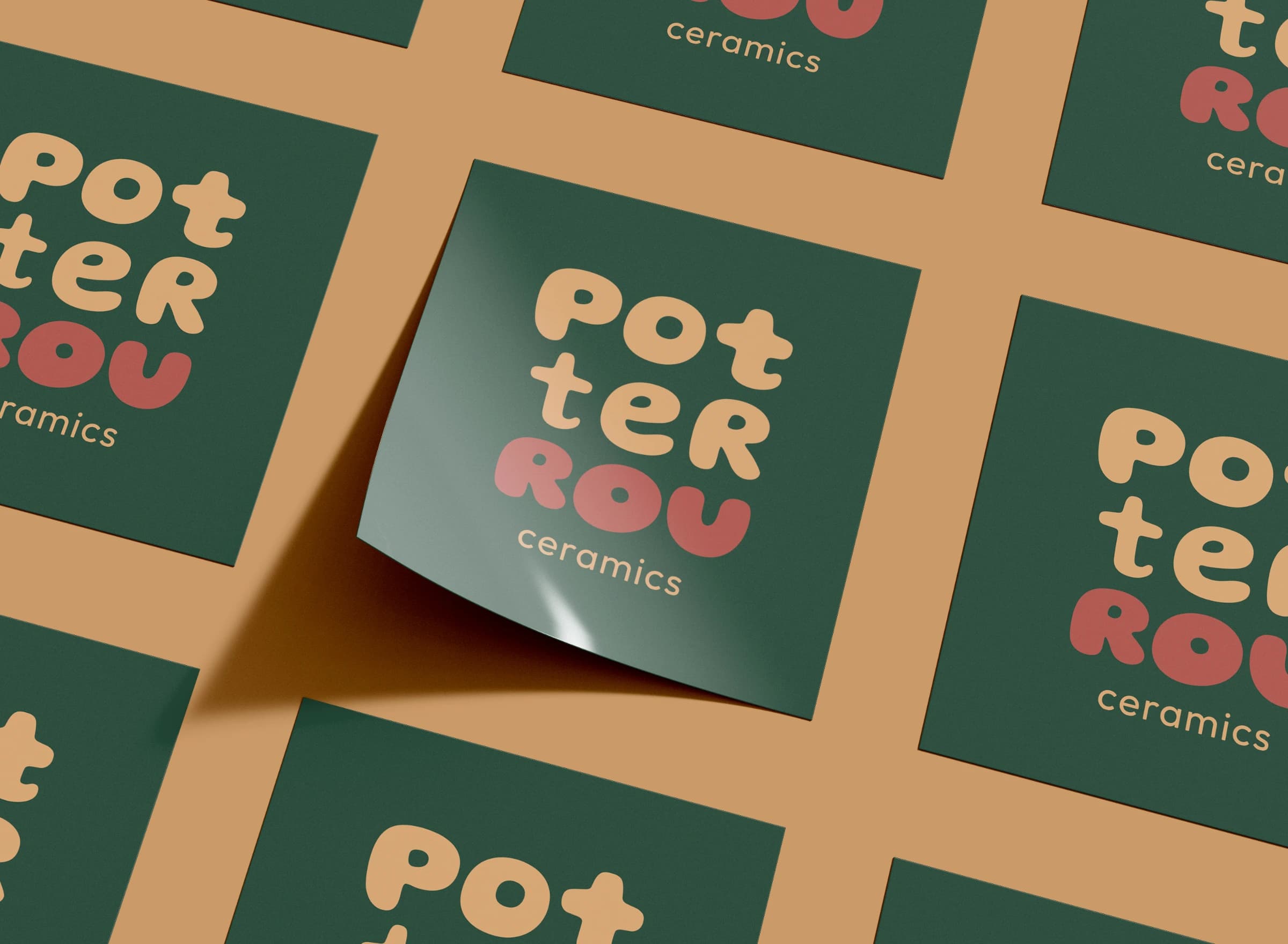 Rows of square PotterRou Ceramics stickers on orange, one peeling up at the corner